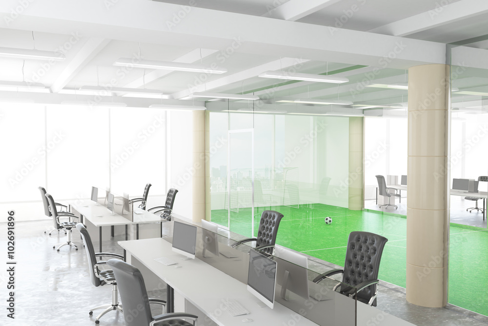 Modern open space office with football field behind the transpar