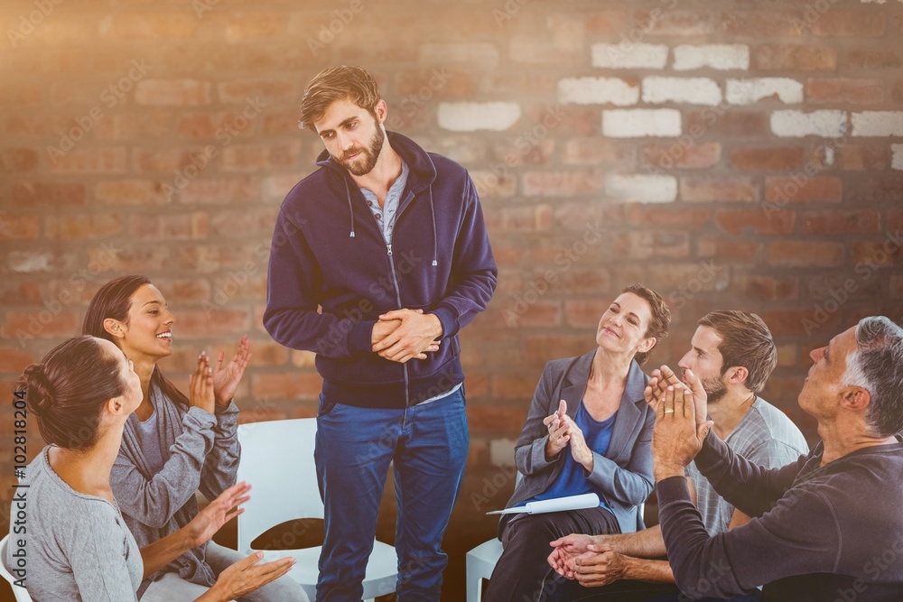 Composite image of rehab group applauding delighted man standing