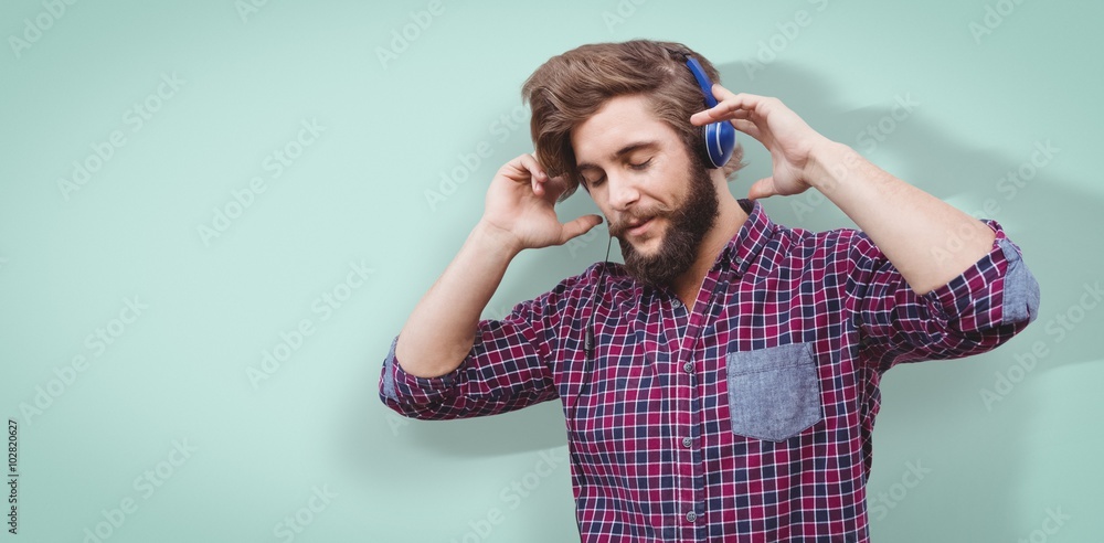 Composite image of hipster wearing headphones