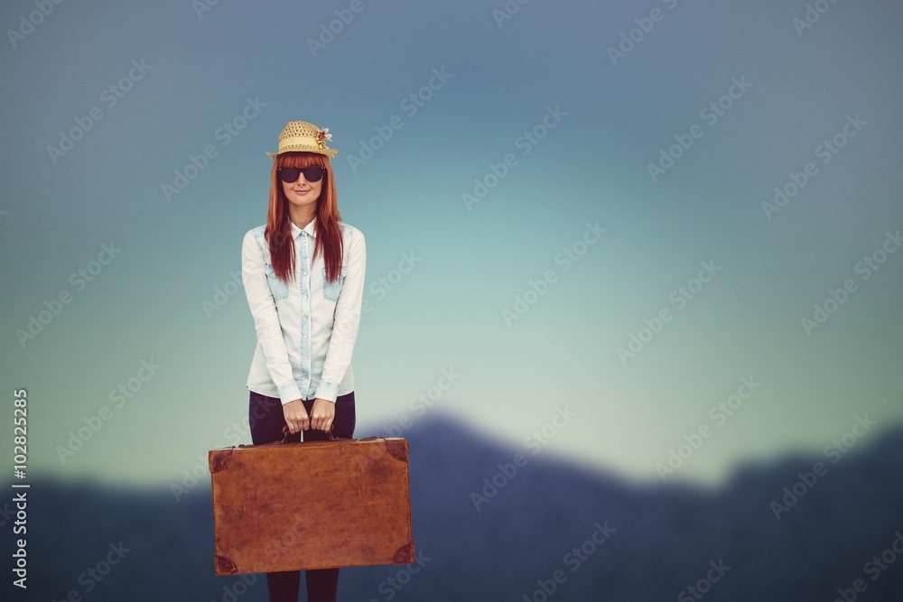 Composite image of portrait of a hipster woman holding suitcase