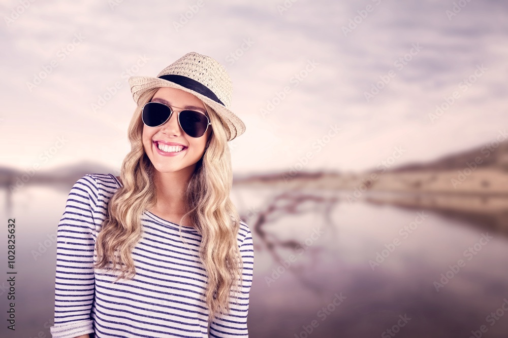 Gorgeous smiling blonde hipster with sunglasses and straw hat