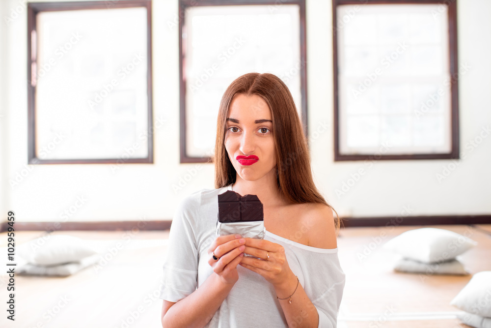 Woman with disappointed emotions holding chocolate