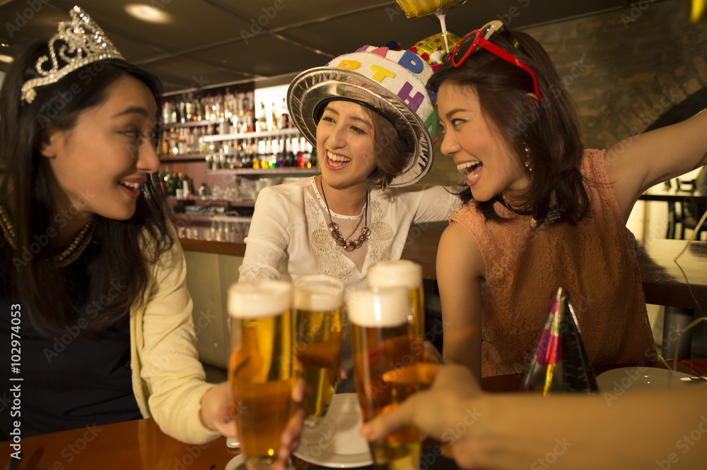 Three women are celebrating a birthday at the bar