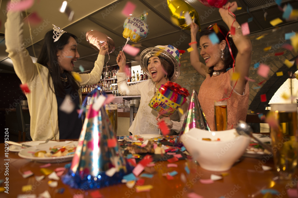 五彩纸屑中的三个女人，庆祝生日