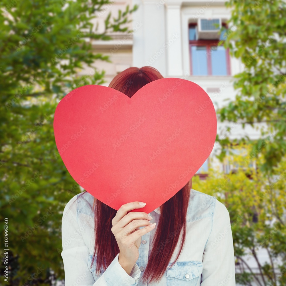 Composite image of attractive hipster woman behind a red heart