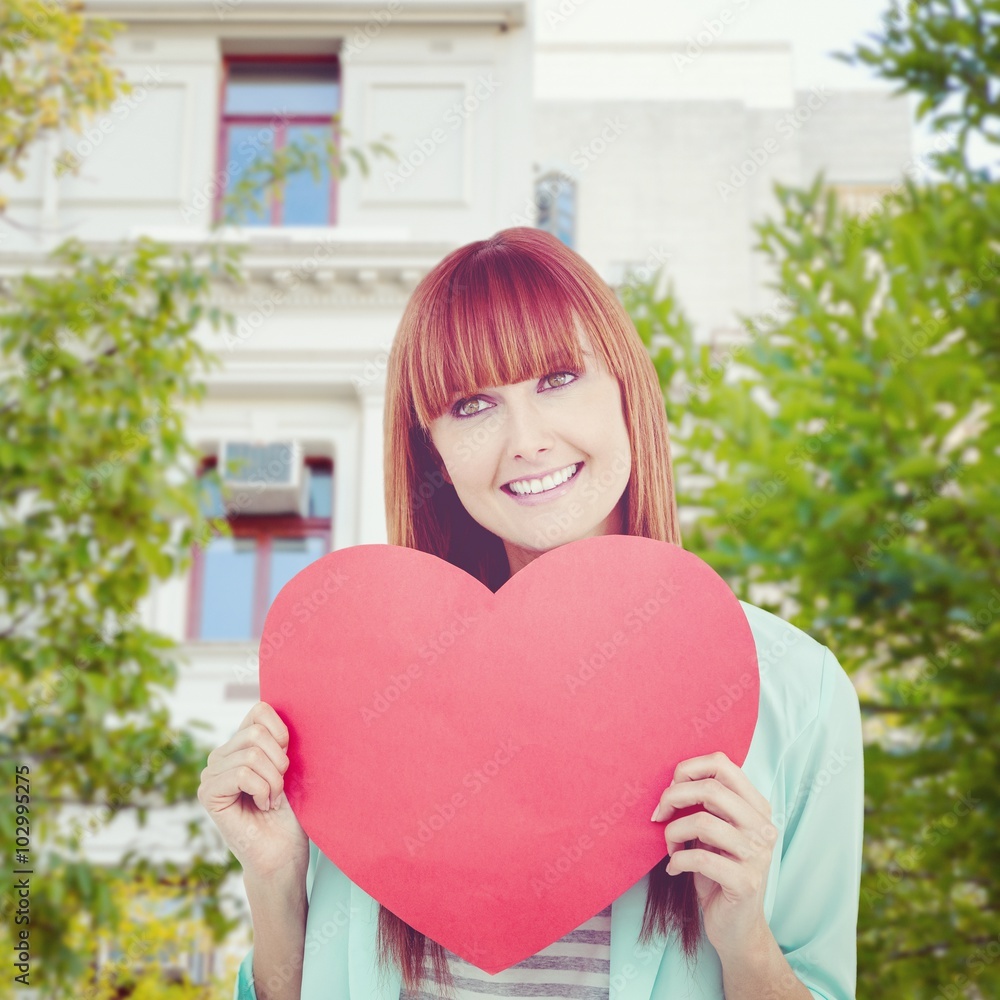 Composite image of smiling hipster woman behind a big red heart