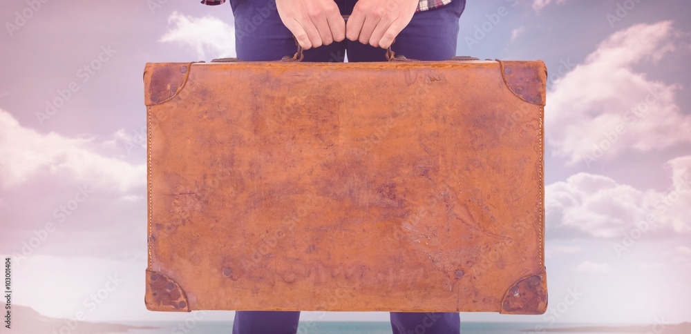 Composite image of mid section of man holding briefcase