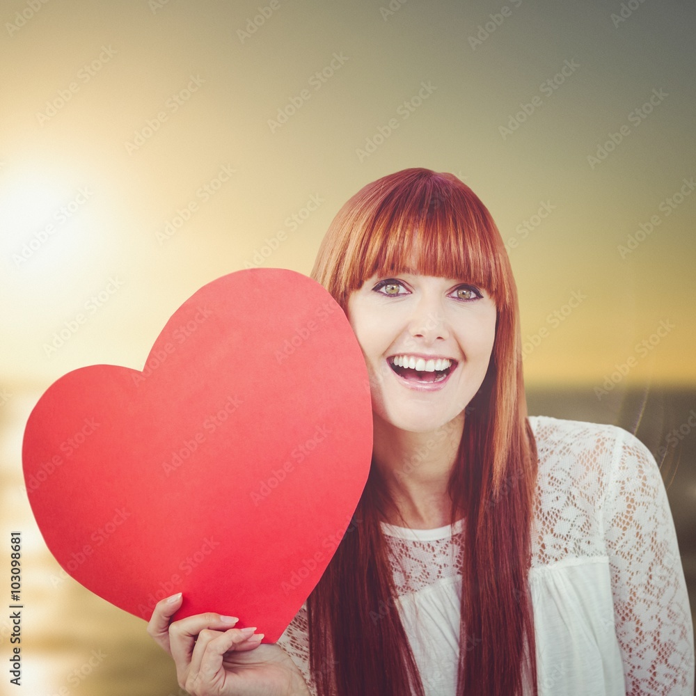 Composite image of smiling hipster woman with a big red heart