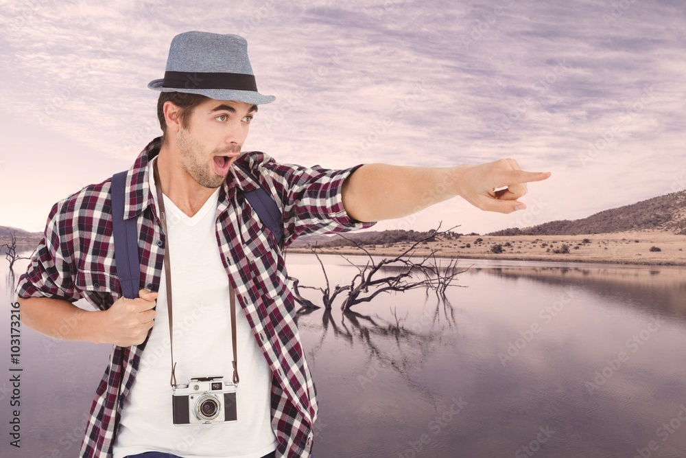 Composite image of surprised man with backpack pointing