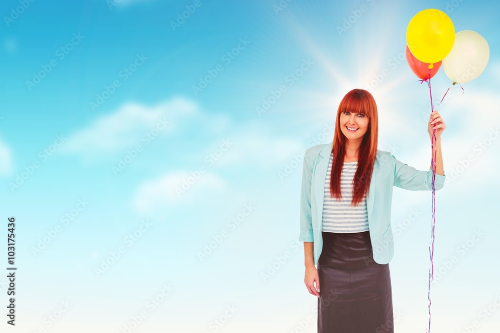 Composite image of smiling hipster woman holding balloons