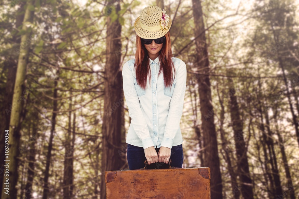 Portrait of a hipster woman holding suitcase