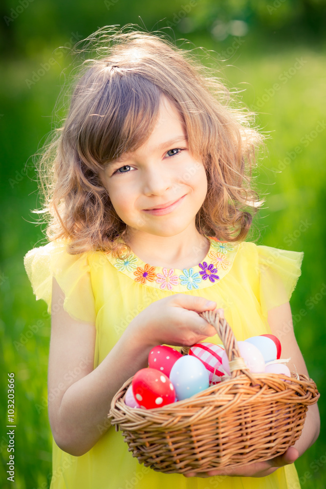 Child holding basket with Easter eggs