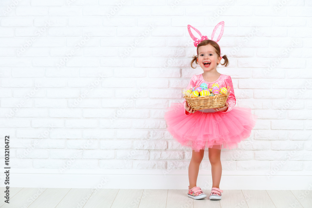 Happy child girl in a costume Easter bunny rabbit with basket of