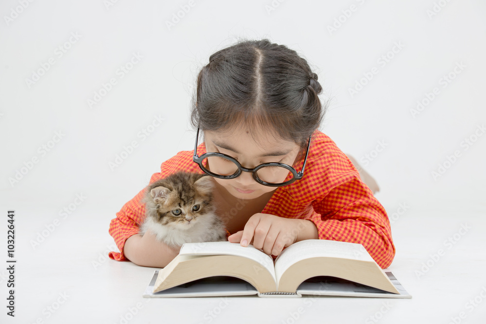 Little Asian girl reading a book with lovely Persian kitten on isolated