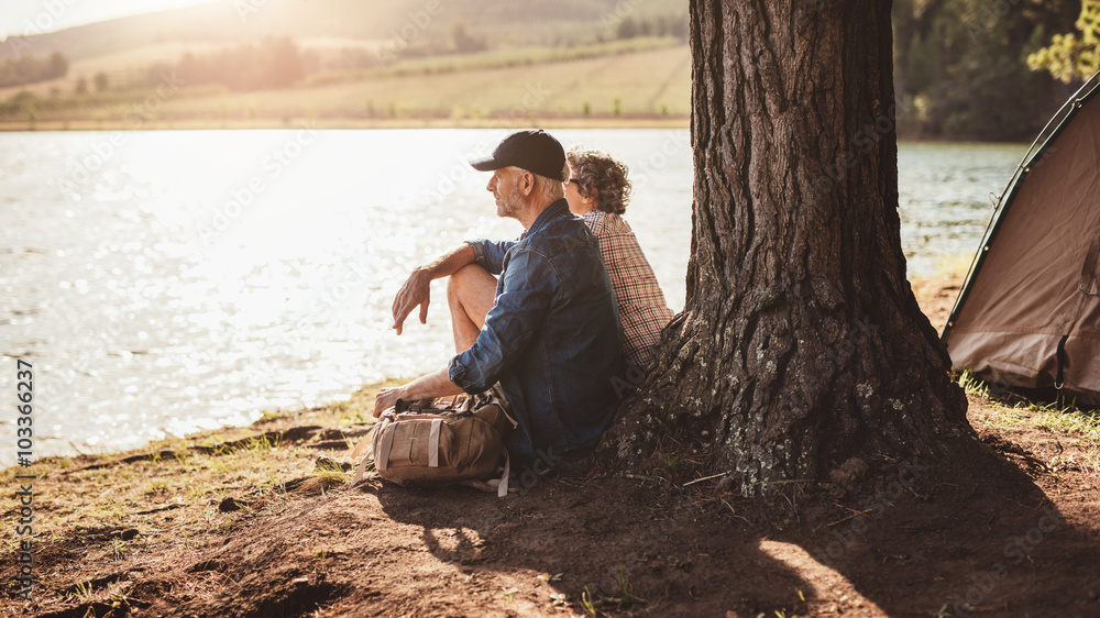 Senior couple camping by a lake