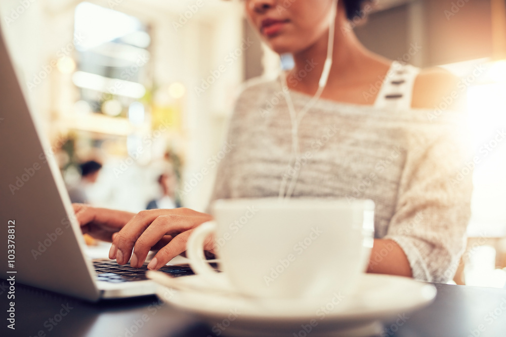 Woman sitting at a coffee shop working on laptop