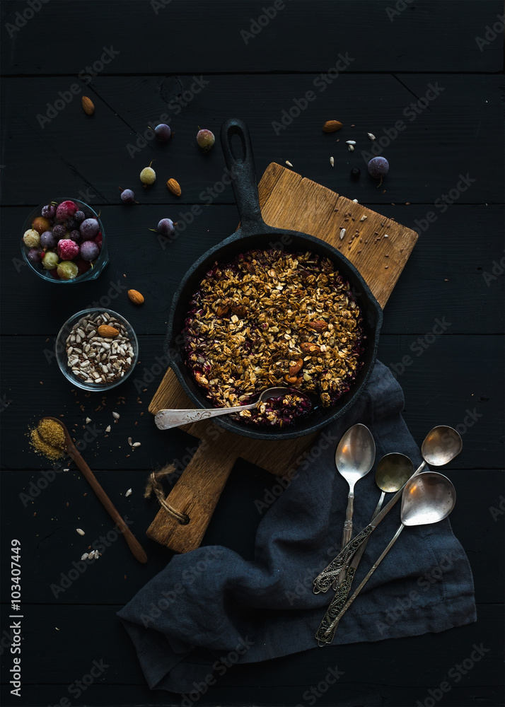 Healthy breakfast. Oat granola crumble with frozen fresh berries, and seeds in irom skillet pan on r