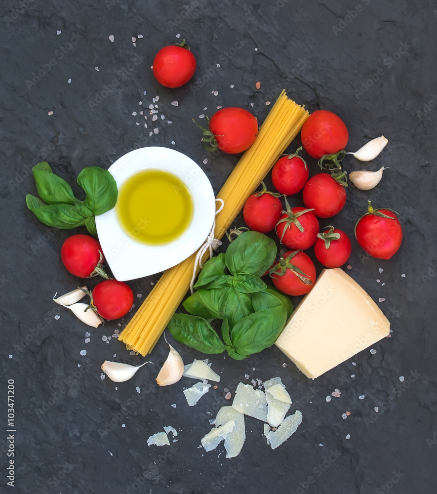 Ingredients for cooking pasta. Spaghetti, olive oil, garlic, Parmesan cheese, tomatoes and fresh bas