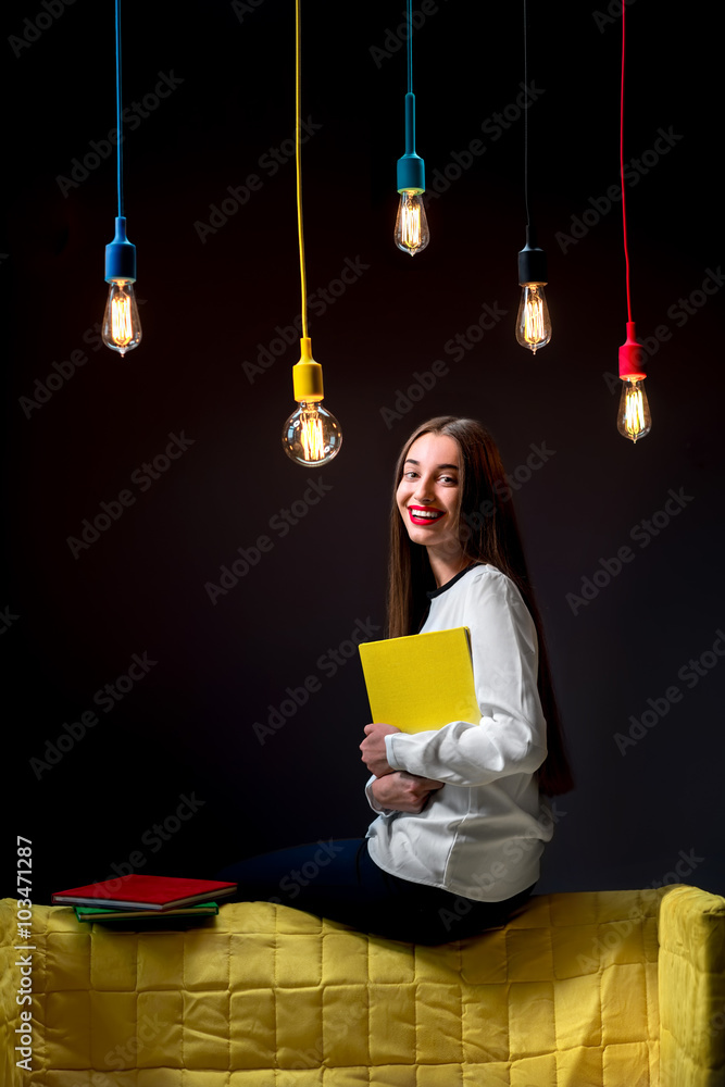 Young creative student with colorful lamps and books