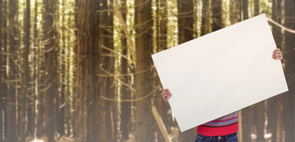 Composite image of hipster woman behind a big white card