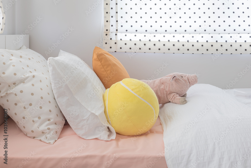 kids bedroom with colorful pillows and dolls