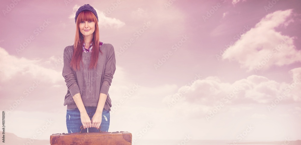 Composite image of smiling hipster woman holding suitcase