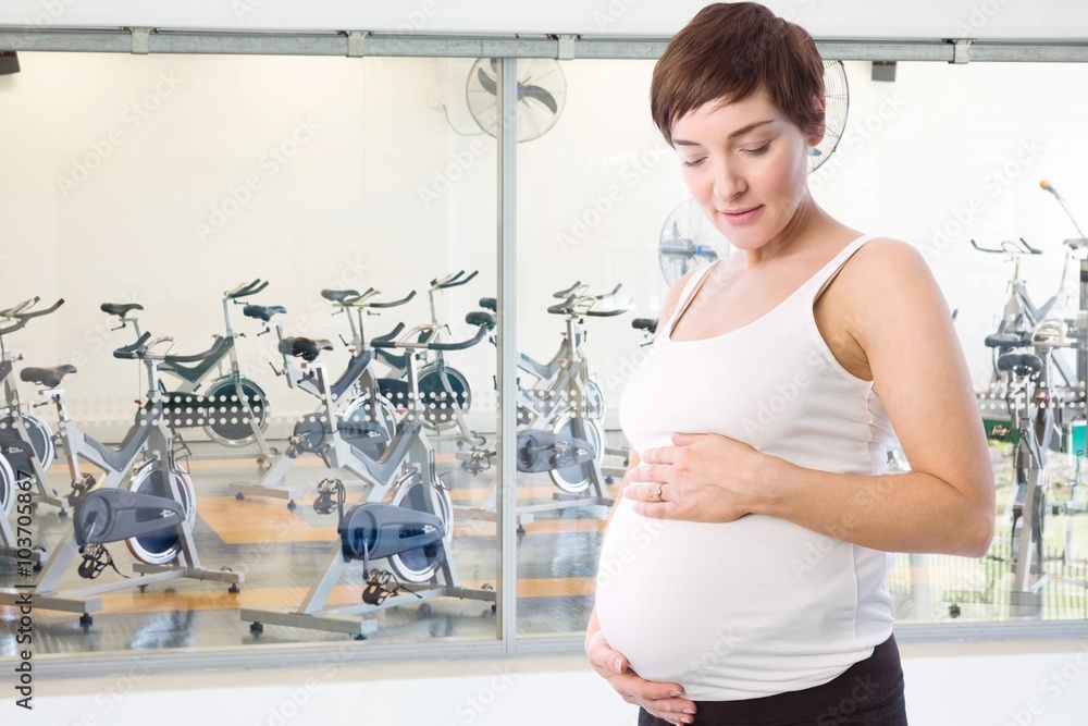 Composite image of relaxed pregnant woman holding belly