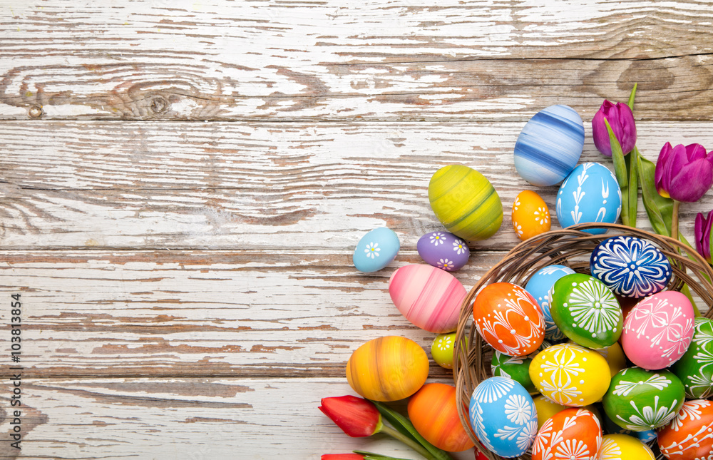 Easter eggs and tulips on wooden planks