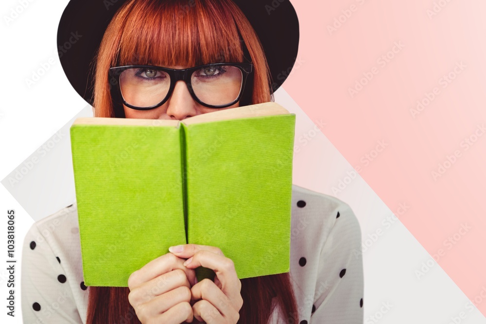 Composite image of hipster woman behind a green book