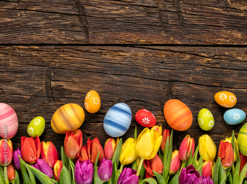 Easter eggs and tulips on wooden planks