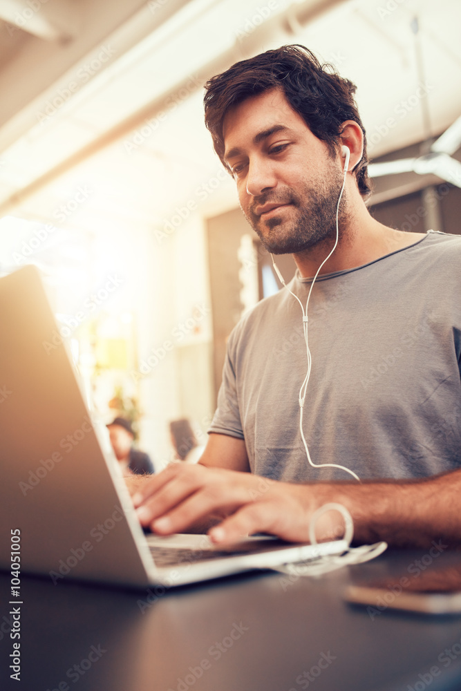 Caucasian man sitting in coffee shop using laptop