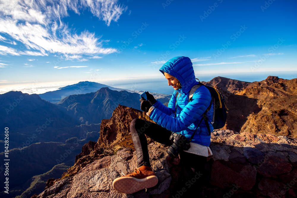 Woman in blue jacket and backpack traveling mountains near Andenes viewpoint on La Palmas island hi