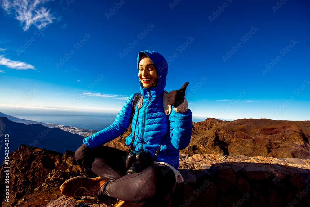 Woman in blue jacket and backpack traveling mountains near Andenes viewpoint on La Palmas island hi