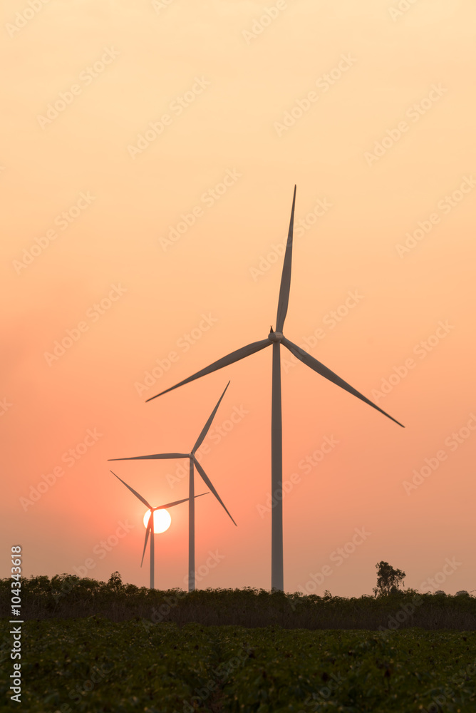 silhouette of wind turbines at sunset