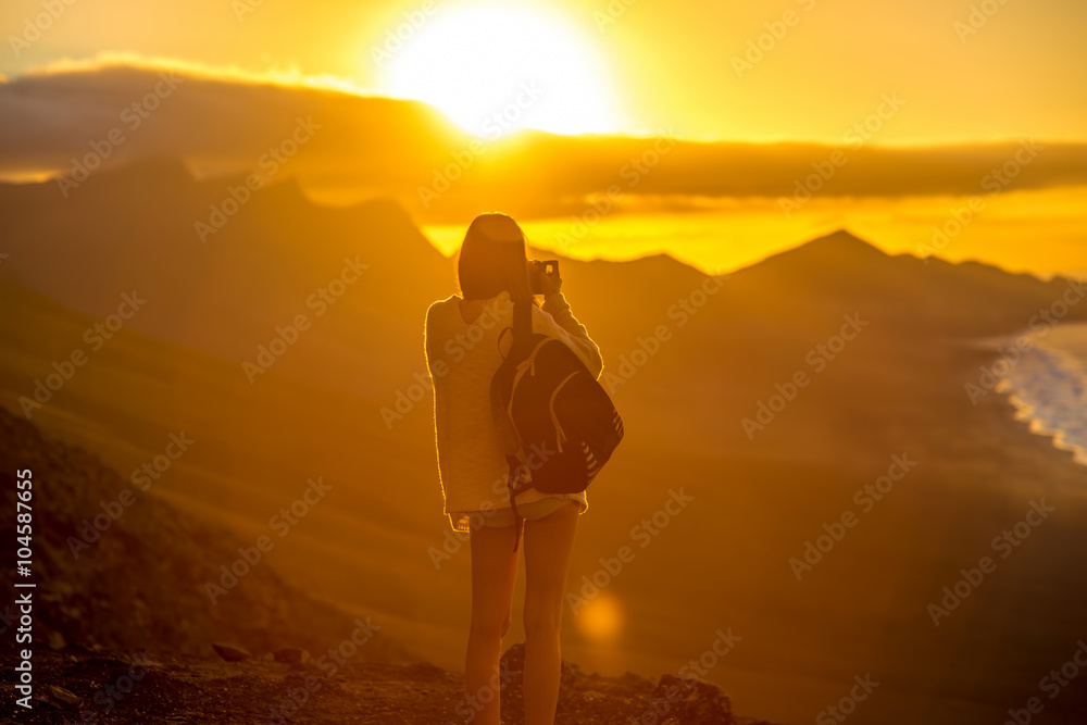 带着背包和相机的年轻女性旅行者用m拍摄美丽的科菲特海岸线