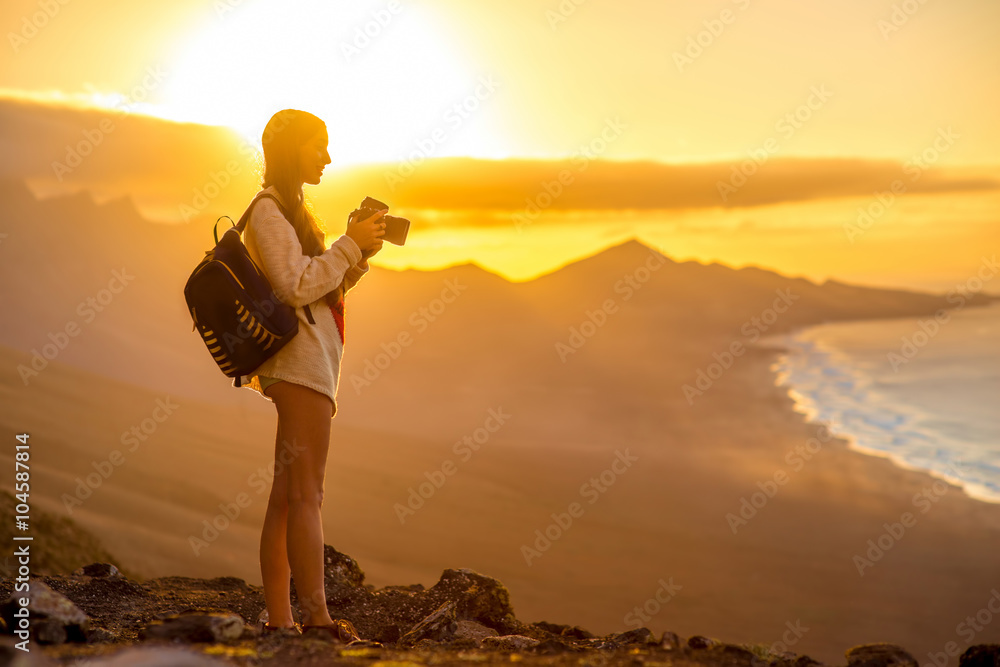 背着背包，带着相机的年轻女性旅行者用m拍摄美丽的科菲海岸线