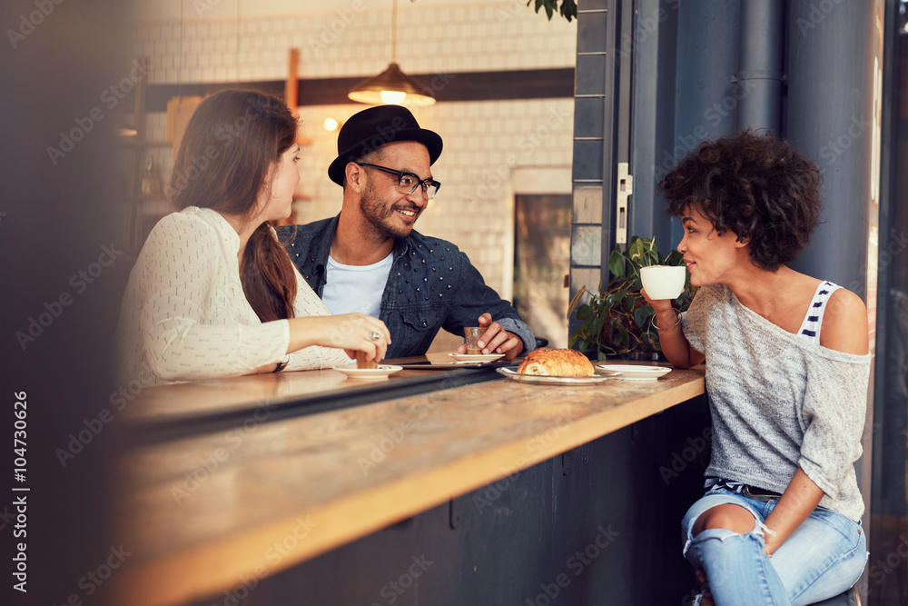 Happy young people sitting in a cafe