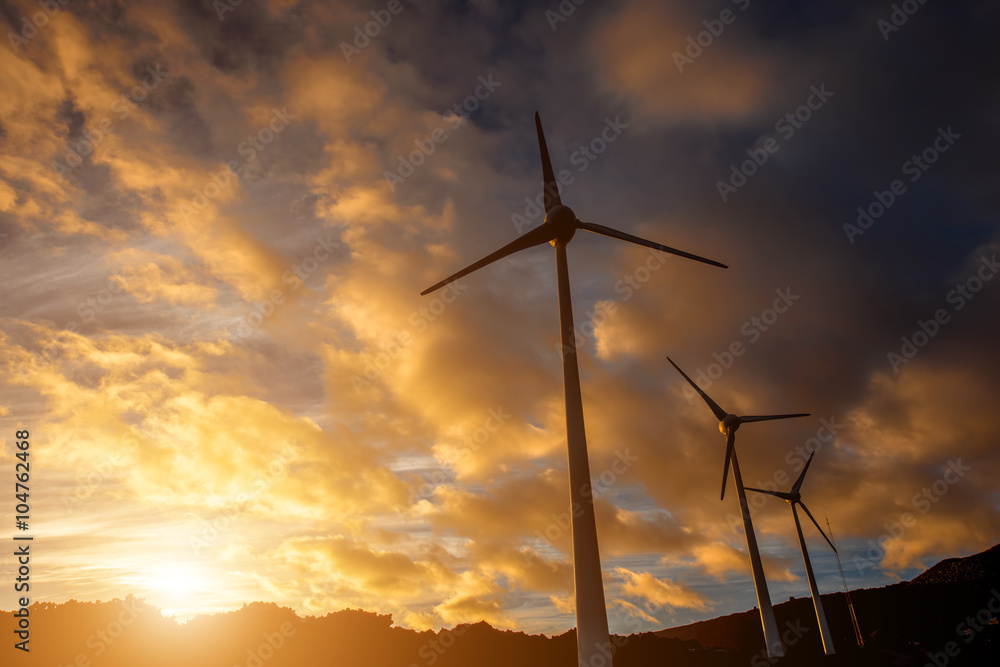 Electric windmills on the sky background on the sunset