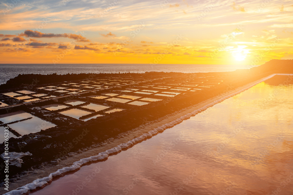 Volcanic pool on the salt manufaturing with pink salt water and sky reflection on the sunset on La P