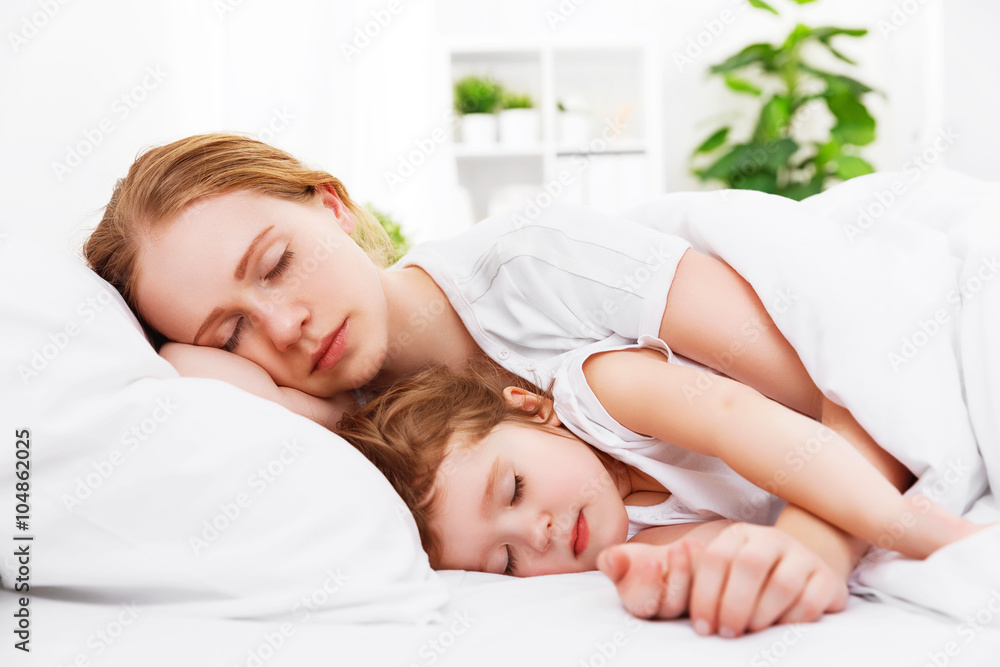 happy family mother and child sleeping in bed