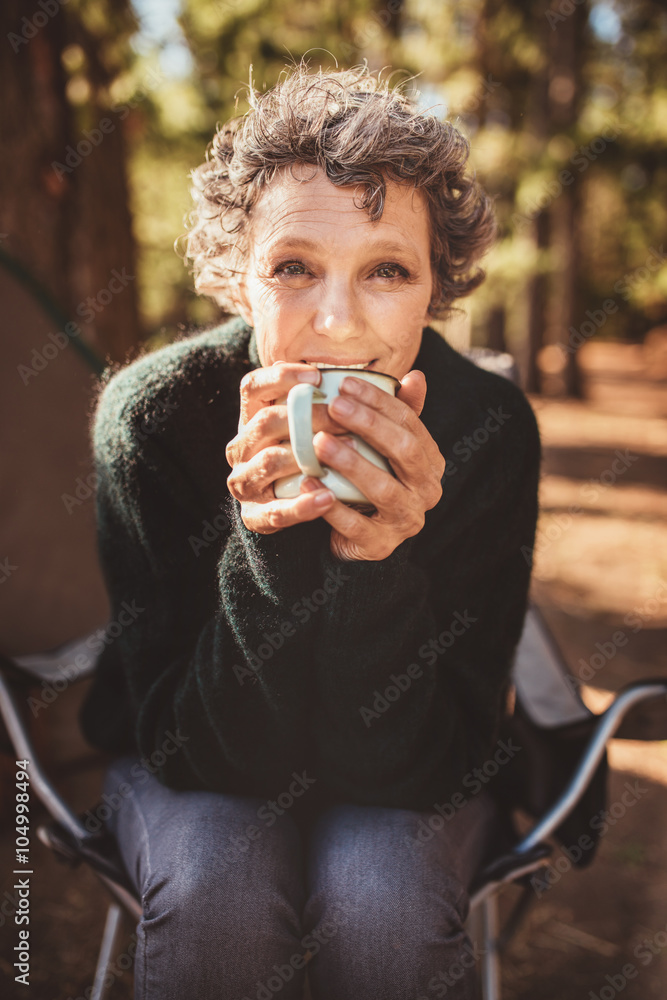 成熟的高加索女人在露营地喝咖啡