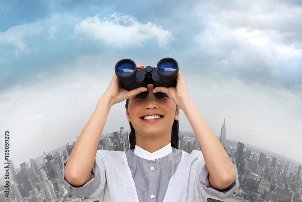 Composite image of businesswoman looking through binocular