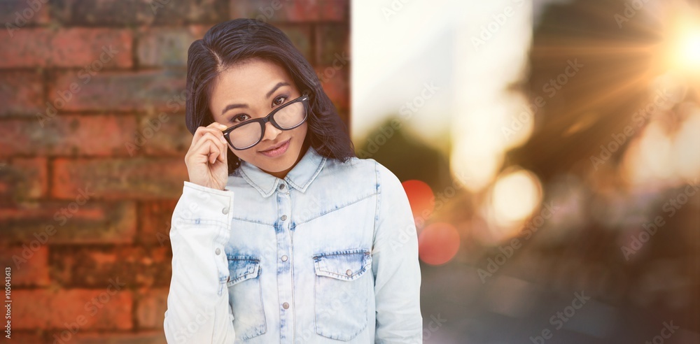 Composite image of asian woman holding eyeglasses