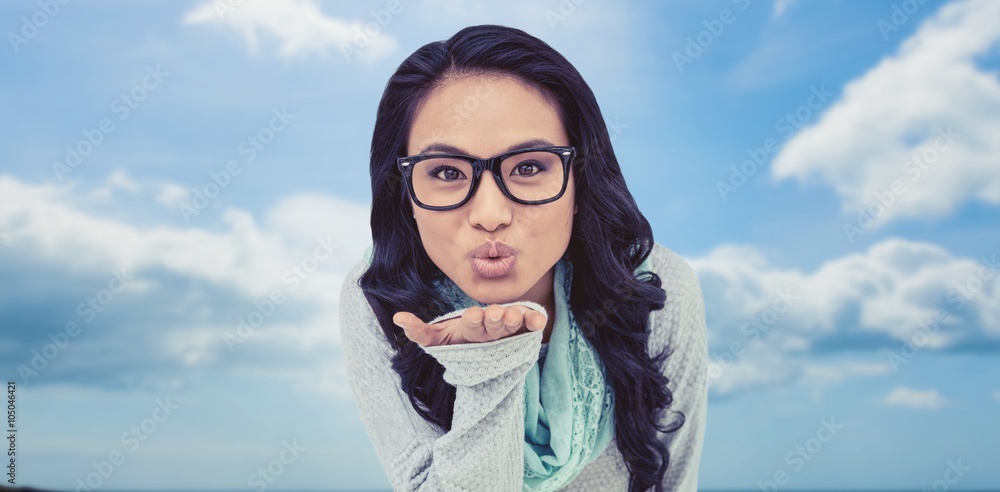 Composite image of asian woman blowing kiss to the camera