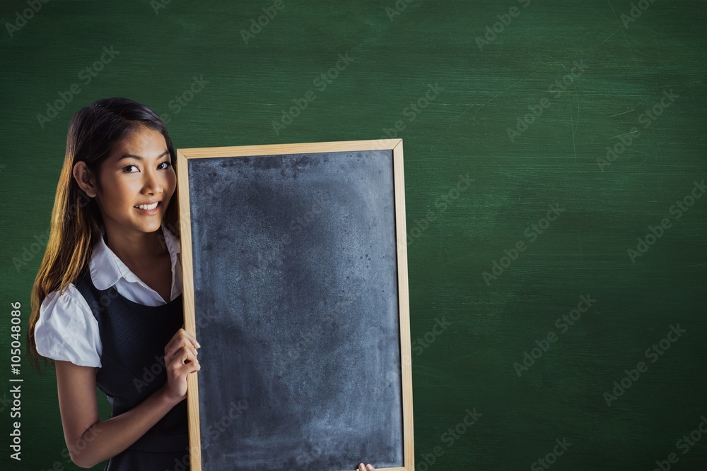 微笑的女商人拿着黑板的合成图像