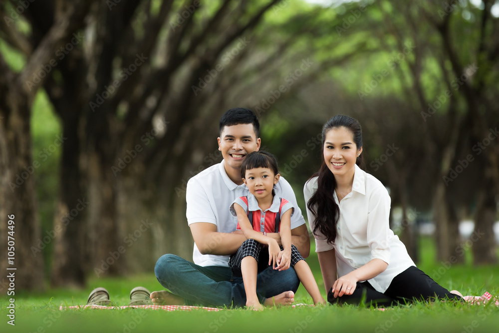 Asian family are sitting at the park. Happily