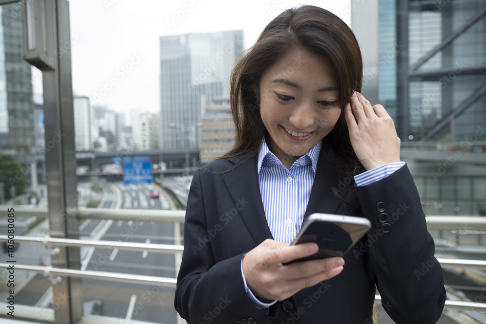 Woman looking at the smartphone in the office district