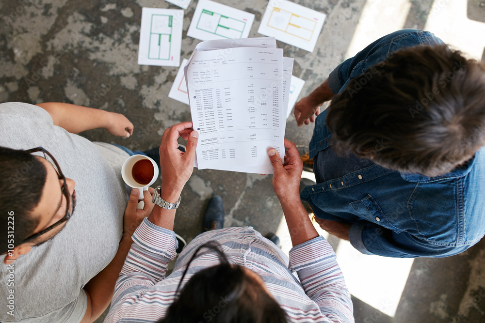 Young people going through financial documents in office