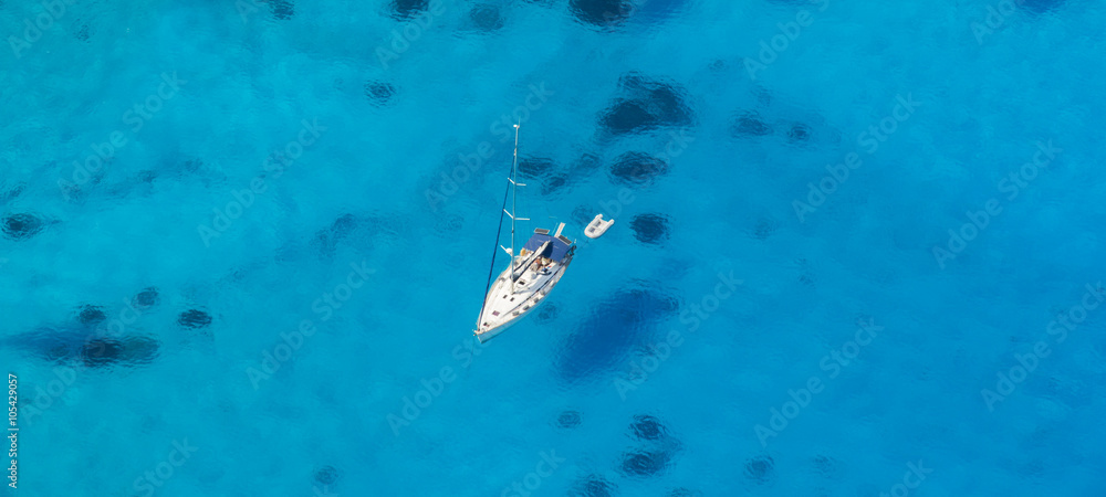 Aerial view of single yacht in azure sea