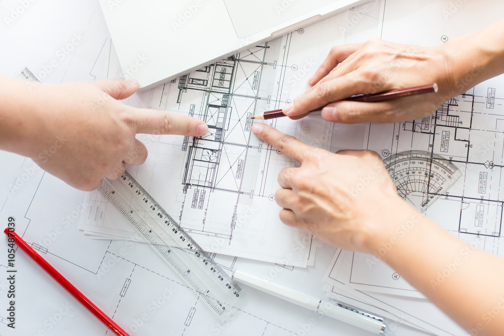 Architects discussing at the table with blueprint - Closeup on h